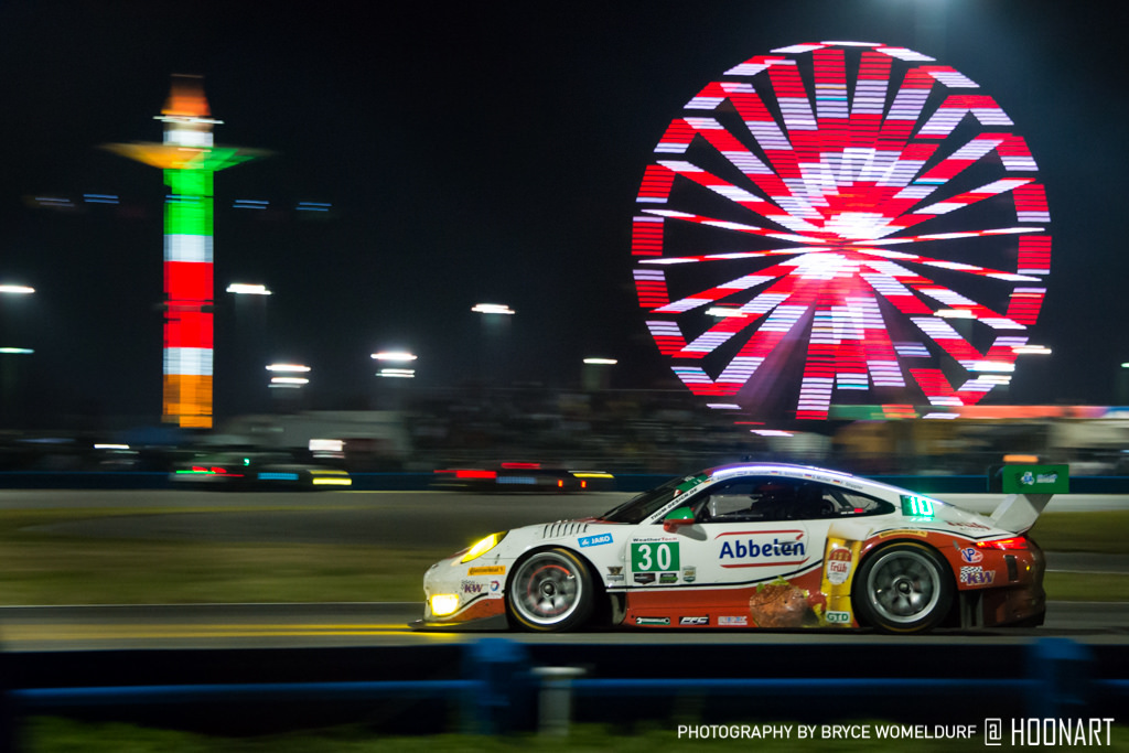 Number 30 car zooming past the ferris wheel at the Rolex24 in Daytona